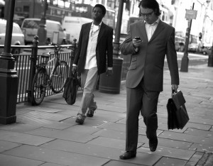 Business Man Checking His Phone as He Walks down the Street