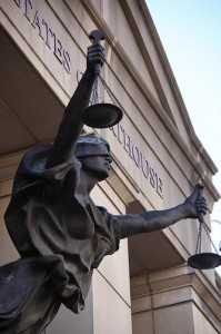 Justice Holding the Scales in Front of a Courthouse