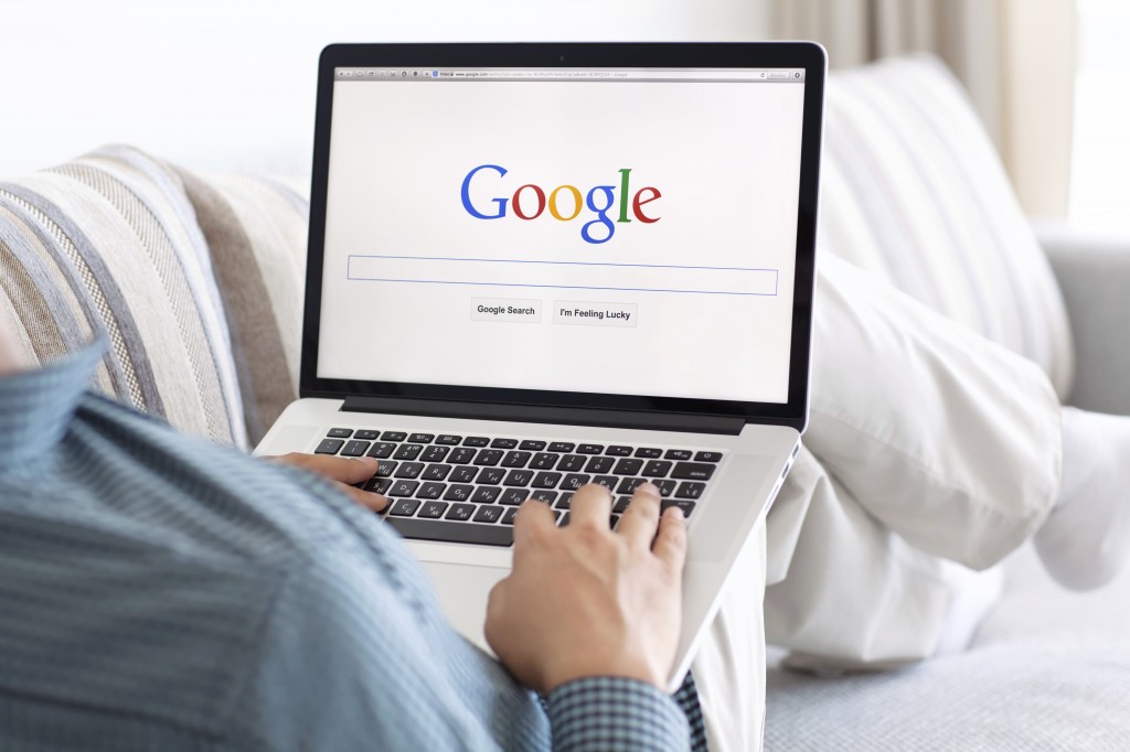 man sitting at the MacBook retina with site Google on the screen